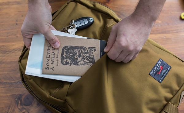 Putting a book and a book of poetry in the front zipper pocket.